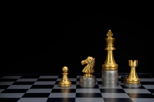 Gold chess with piles of coins on the board. Plan the use of money. Money game concept. Copy space. Selective focus.