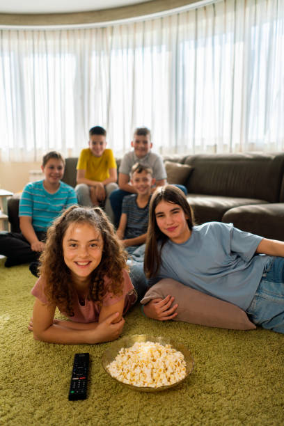 istock Smiling children watching movie together 1701860975