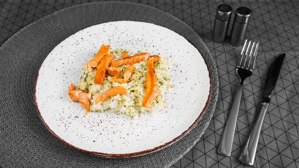 risotto al salmone in un piatto di argilla bianca fatto a mano sul tavolo - main course salmon meal course foto e immagini stock