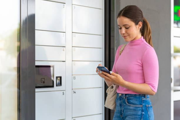 istock Young woman taking a package out of an automatic mailbox 1701879307