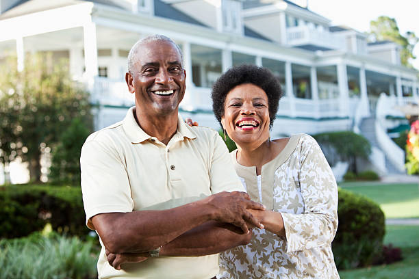 Mature African American couple at country club Mature African American couple (50s and 60s) at a country club, standing in front of clubhouse.  Main focus on woman. rich black men pictures stock pictures, royalty-free photos & images