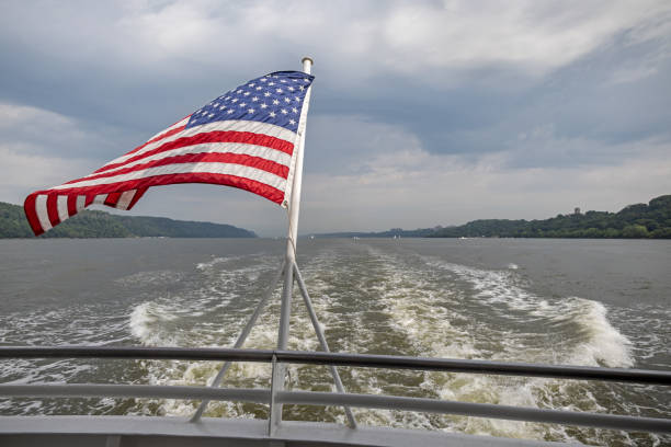 bandiera americana e sveglia dietro una barca - new york state new york city vanishing point national landmark foto e immagini stock
