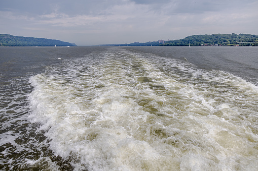 Wake after a fast tour boat sailing down Hudson River, New York