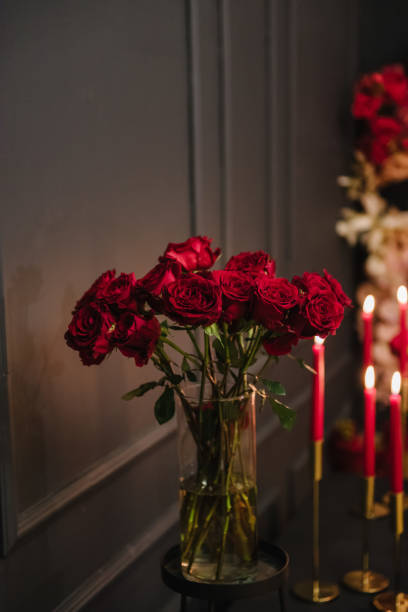 istock Romantic date in restaurant. Luxury candlelight setup decor for couple on Valentine's day. Location with arch, wall, photo zone decoration flowers, decor with candles for surprise marriage proposal. 1701907434