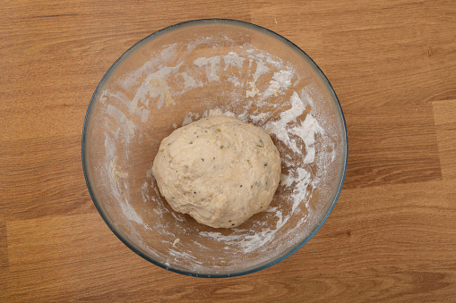 A kneaded ball of yeast dough placed in a glass rising bowl, top view