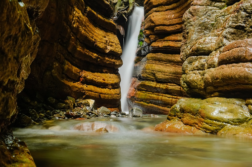 soft little waterfall in the red canyon with lot o layers of the rocks in austria