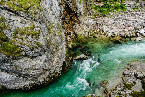 cold green white water and huge rocks in a gorge during hiking in salzburg
