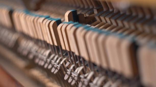 istock Upright Piano Mechanism Hammers Striking Strings When Song is Played by Musician 1701912134