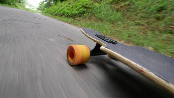 istock Longboard Skateboard with Orange Wheels Riding Downhill Asphalt Road POV 1701912685