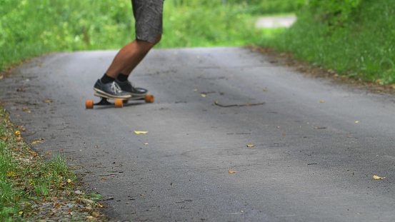 Man Riding Longboard Skateboard on Asphalt Road Slow Motion