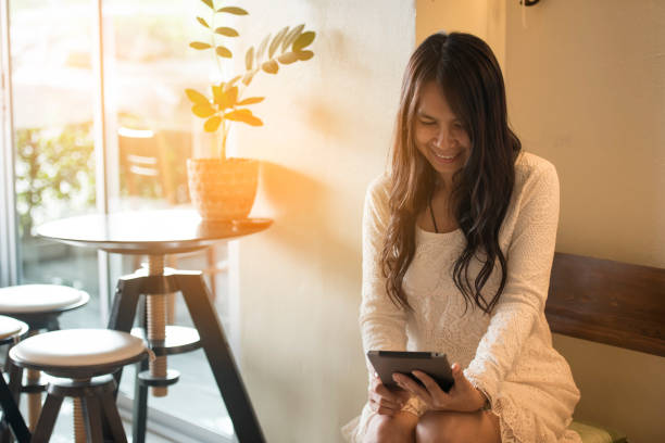istock Asian woman using digital tablet shopping online, call, texting message internet technology lifestyle with smiling face. Asian woman touch smart tablet focus on hands using mobile app home office. 1701931153
