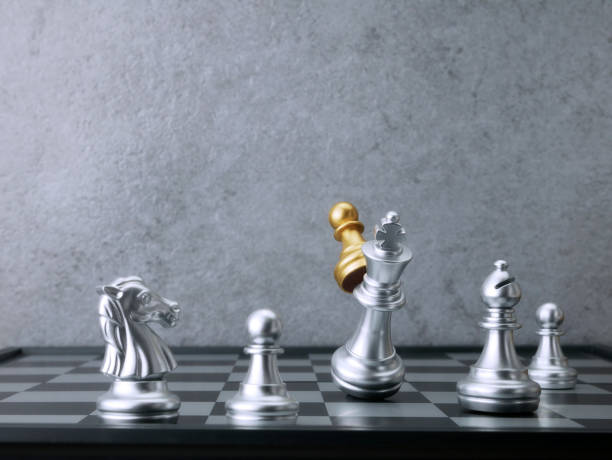 istock Golden pawn chess attack silver king chess. Leadership Concepts. 1701932483