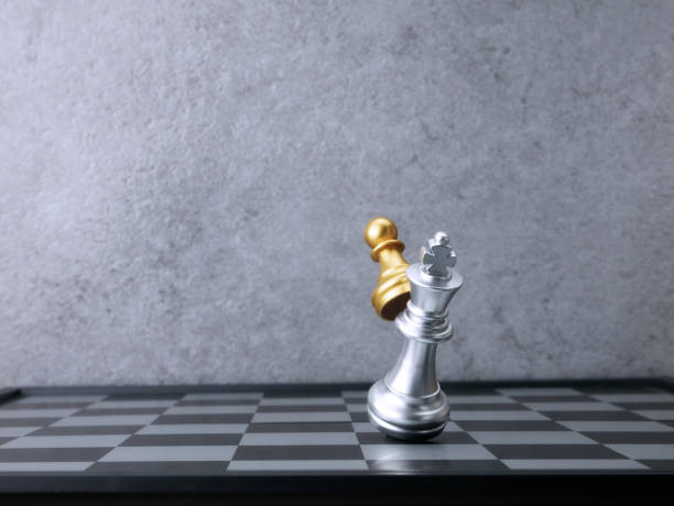 istock Golden pawn chess attack silver king chess. Leadership Concepts. 1701934262