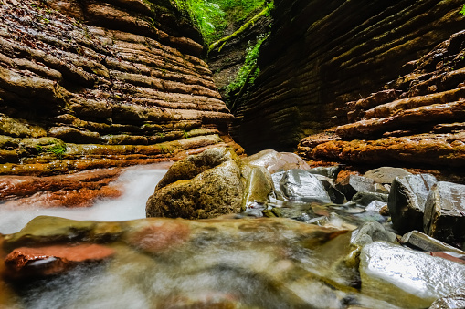wonderful red canyon with lot of layers of the red rocks and a soft flowing cold brook in austria