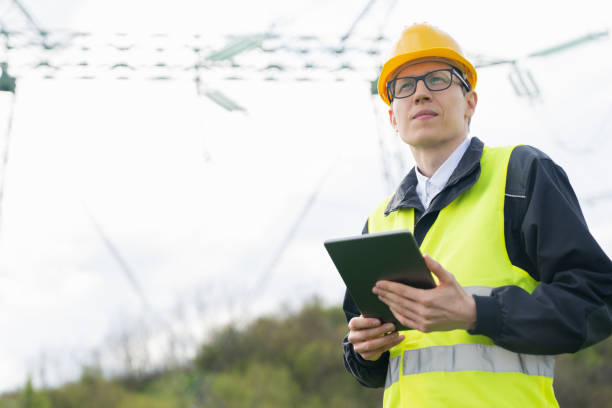 istock Engineer with digital tablet on a background of power line tower 1701957377
