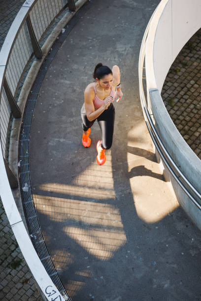 istock High angle view on young active woman running on round pedestrian walkway 1701966553