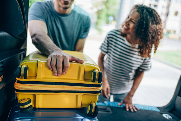 istock Young couple packing and loading luggage into car trunk for their vacation. 1701982050