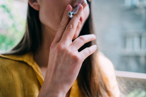 giovane donna che fuma una sigaretta all'aperto. - smoking women smoke smoking issues foto e immagini stock