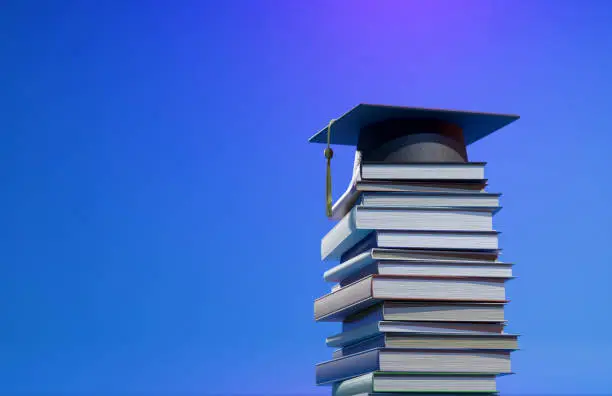 Photo of Education concept, graduation cap, books, and graduation scroll. Congratulations graduates