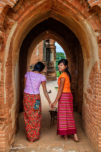Young Burmese girls with thanaka face paint posing in the ancient temple of Bagan, Myanmar (Burma)
