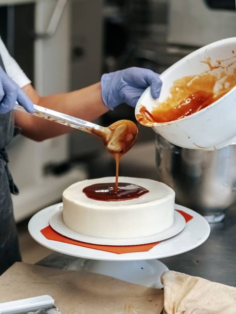 istock Pastry chef pouring caramel on cake close-up 1701993362
