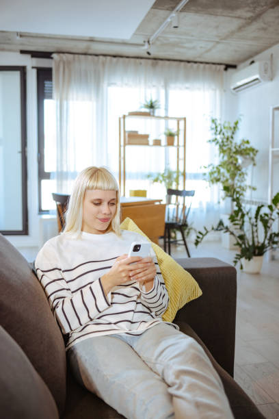 istock Young woman relaxing at home and using smart phone 1701993935