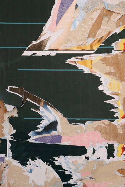 istock Pieces of torn paper peeling off wall used as billboard 1701993948