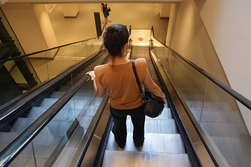 Woman going down the escalator