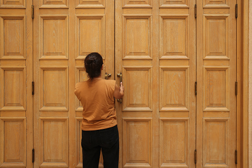 Woman stands at a wooden door