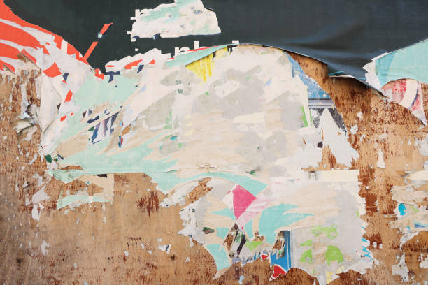 istock Pieces of torn paper peeling off wall used as billboard 1701993959