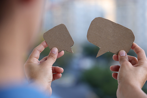 Woman holding blank paper speech bubble