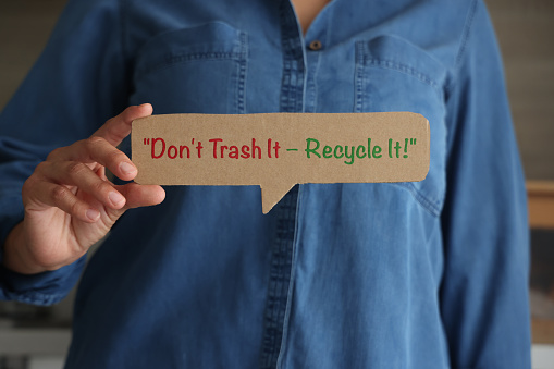 Woman holding speech bubble with recycle message