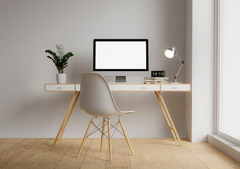 A modern PC computer blank screen mockup is on a table in a modern minimal home office. 3d render illustration.