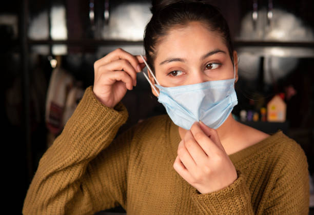 istock Woman wearing protective face mask at home. 1702016626
