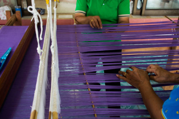 istock Thai craftsmanship technician professional use antique local wooden machine loom weaving hand woven cotton fabric for show travelers visit in studio workshop of handmade crafts in Nonthaburi, Thailand 1702023070