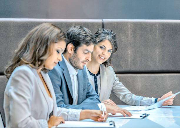 Portrait of business woman giving you a warm smile during a meeting with colleagues