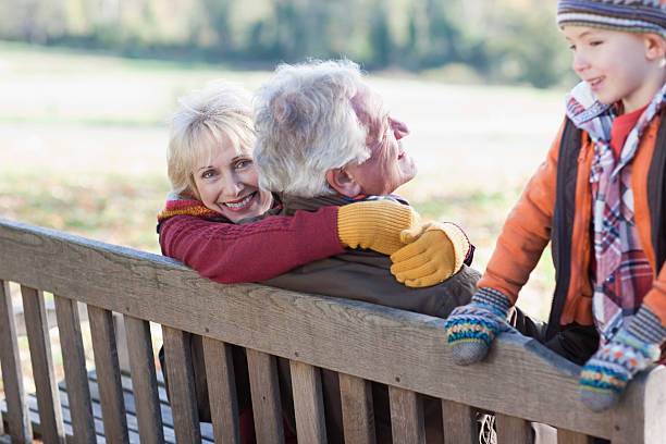 grands-parents et petit-fils jouant dans le parc - generation gap multi generation family vertical holding hands photos et images de collection