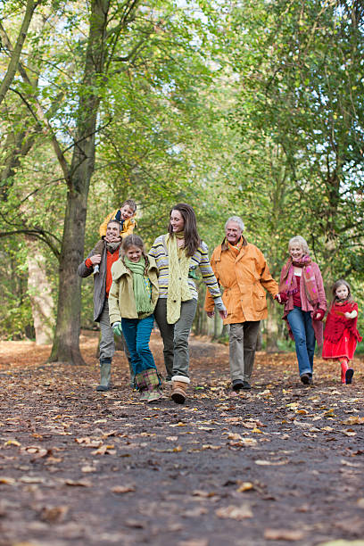 familia caminando al aire libre en otoño - coat grandfather grandchild granddaughter fotografías e imágenes de stock