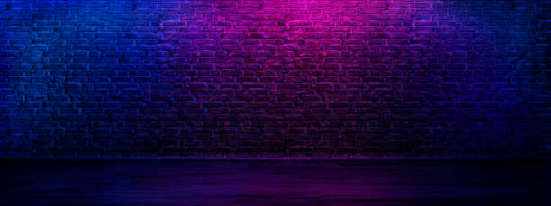 istock Neon brick wall textured background. Grunge interior room with led lights. 1702025967