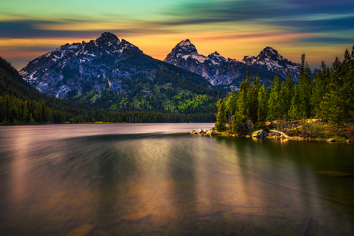 Sunset over Taggart Lake and Grand Teton Mountains in Wyoming, USA. Taggart Lake is a stunning alpine lake in Grand Teton National Park, surrounded by majestic mountains. Long exposure.