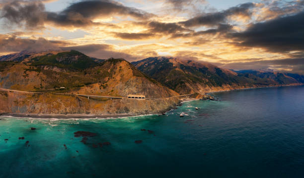 Sunset over Pitkins Curve Bridge and Rain Rocks Rock Shed in California Sunset over Pitkins Curve Bridge and Rain Rocks Rock Shed along Pacific Coast Highway and Big Sur coastline in California, USA. city of monterey california stock pictures, royalty-free photos & images