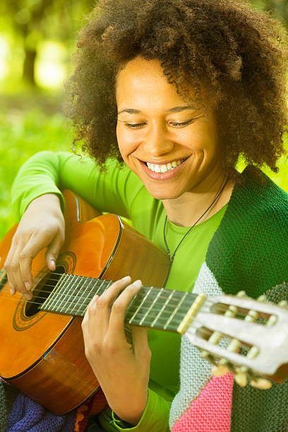 istock Casual girl playing guitar in a park 170204476
