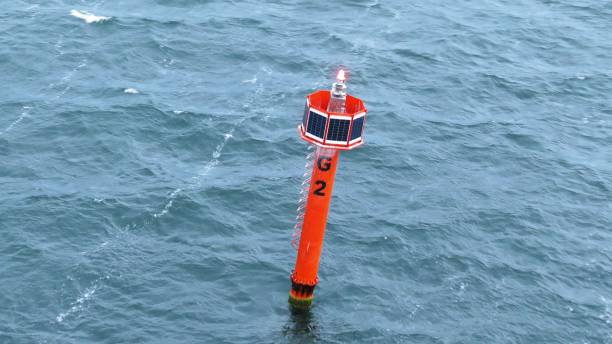 проходя мимо маяка red buoy, плавающего по балтийскому морю - buoy anchored sea wave стоковые фото и изображения