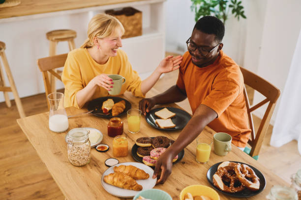istock Multiracial couple enjoying breakfast together at home 1702077819