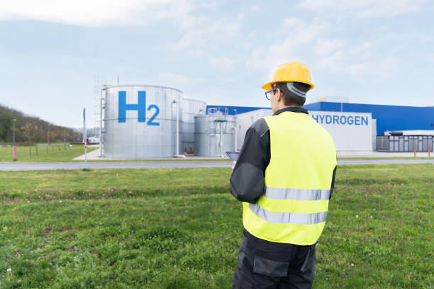 istock Engineer with tablet computer on a background of Hydrogen factory 1702079052