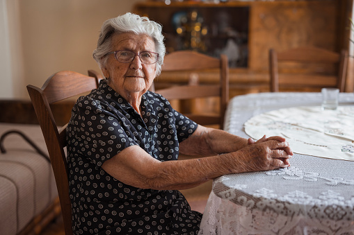 Portrait of an elderly lady with silver hair and glasses, when relaxing at her home