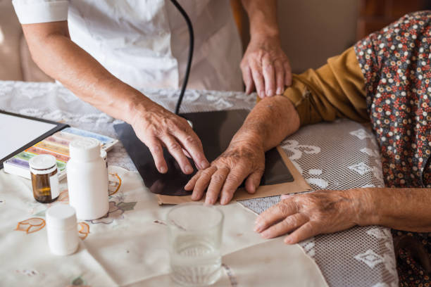 Close-Up: Elderly woman expressing arm pain during home visit examination by doctor