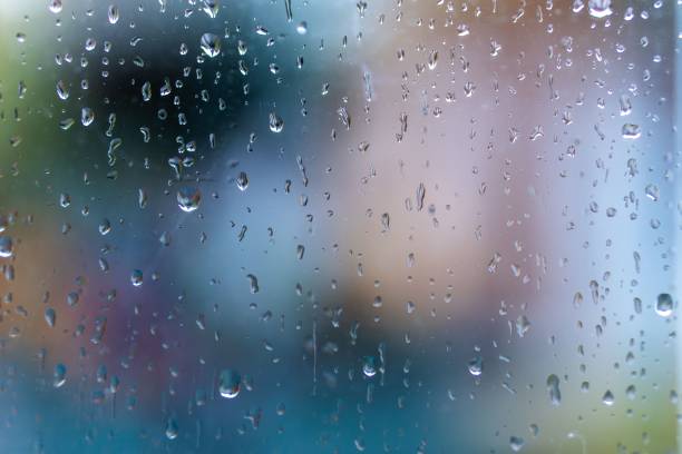 istock Close-up of a glass window with rain droplets on its surface 1702105127