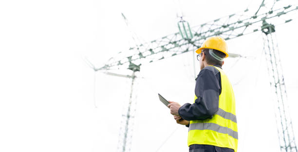 istock Engineer with digital tablet on a background of power line tower. 1702112452