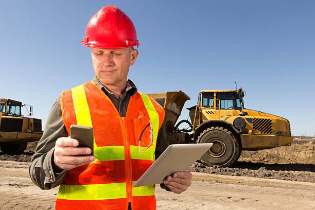 стройплощадка многозадачность - digital tablet construction truck manual worker стоковые фото и изображения